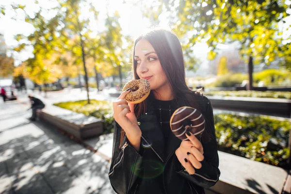 Jong meisje donut eten in park herfst achtergrond — Stockfoto