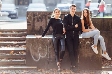 Üç arkadaş park üzerinde oturup konuşmak