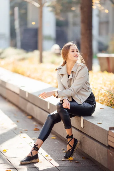 Vacker kvinna sitta på bänken och leende — Stockfoto