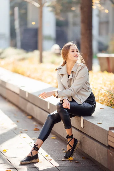 Jolie femme assise sur le banc et sourire — Photo