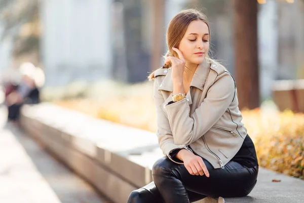 Mujer bonita sentarse en el banco y sonreír — Foto de Stock