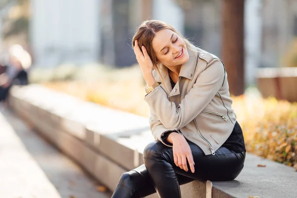 Bella donna sedersi sulla panchina e sorridere — Foto Stock