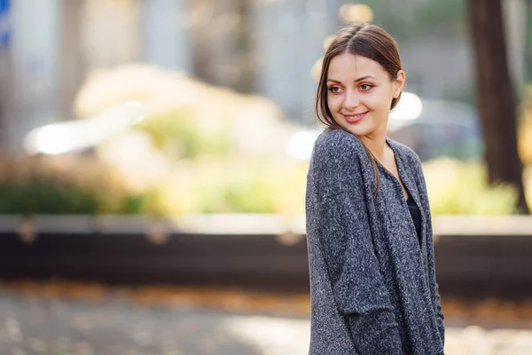 Tyttö seisoo kadulla ja hymyilee kameralle — kuvapankkivalokuva