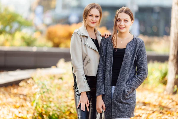 Deux filles s'assoient sur le banc et se lancent à la caméra — Photo