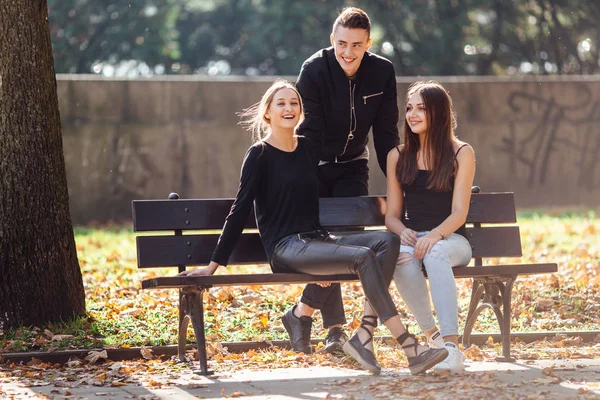 Tre amici si siedono sul parco e parlano — Foto Stock