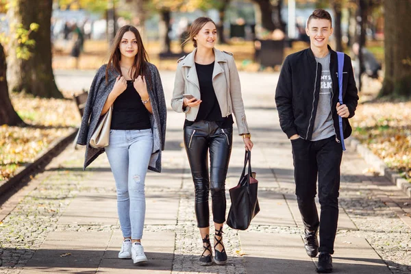 Drie vrienden lopen op straat — Stockfoto