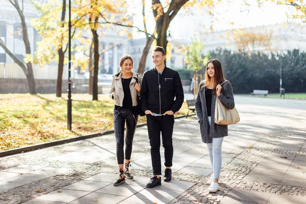 Trois amis marchent dans la rue — Photo