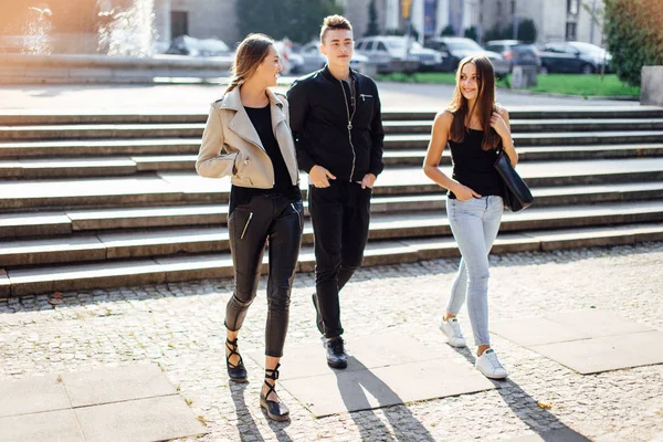 Três amigos caminham na rua — Fotografia de Stock