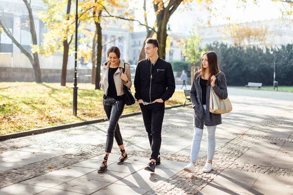 Três amigos caminham na rua — Fotografia de Stock