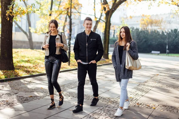 Tre vänner gå på gatan — Stockfoto