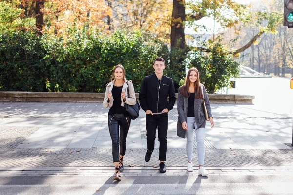 Tre vänner gå på gatan — Stockfoto