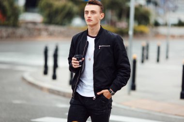 Bir fincan kahve ile sokakta adam yürüyüş