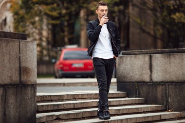 Bir fincan kahve ile sokakta adam yürüyüş