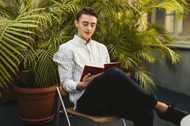 Kütüphane ve okuma kitap ile adam oturup arka plan bulanıklık