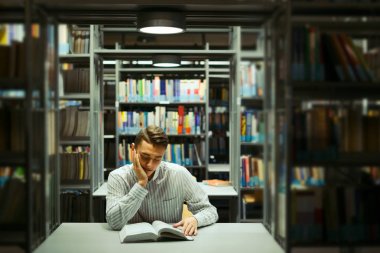 Kütüphane ve okuma kitap ile adam oturup arka plan bulanıklık