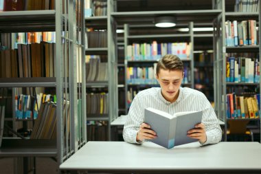 Kütüphane ve okuma kitap ile adam oturup arka plan bulanıklık