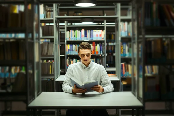 Kütüphane ve okuma kitap ile adam oturup arka plan bulanıklık — Stok fotoğraf