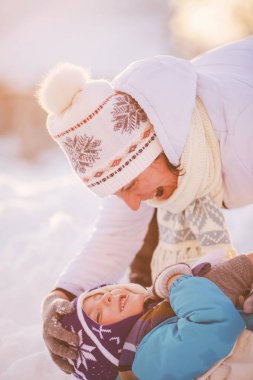 Eğleniyor, kış oynarken mutlu aile anne ve çocuk güneş 