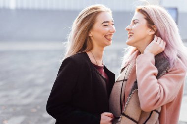 İki kız konuşurken birbirlerine ve gülüyor, sonbahar giyim için