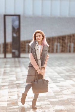 Kız güzel moda yürümek çanta ve gülümseme ile sokakta 