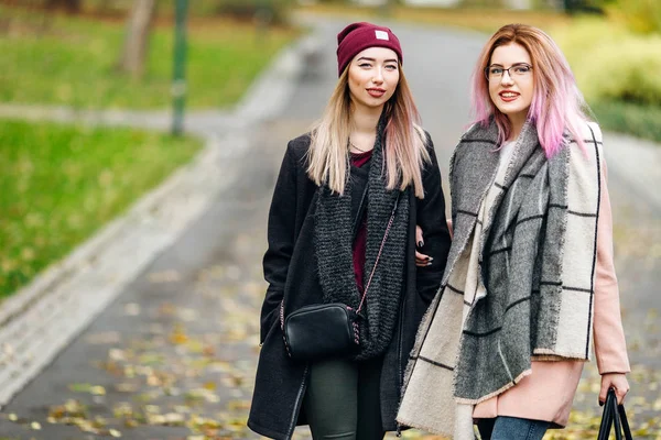 İki kız konuşurken birbirlerine ve gülüyor, sonbahar giyim için — Stok fotoğraf