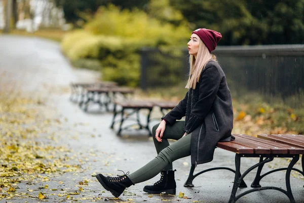 Mädchen sitzt auf der Bank und wartet auf ihre Freunde — Stockfoto