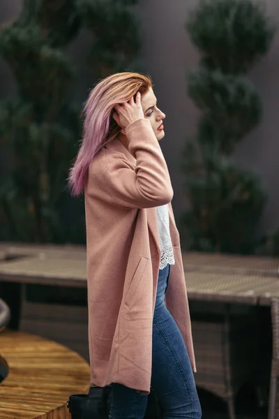 Fille debout dans la rue et pose à la caméra — Photo