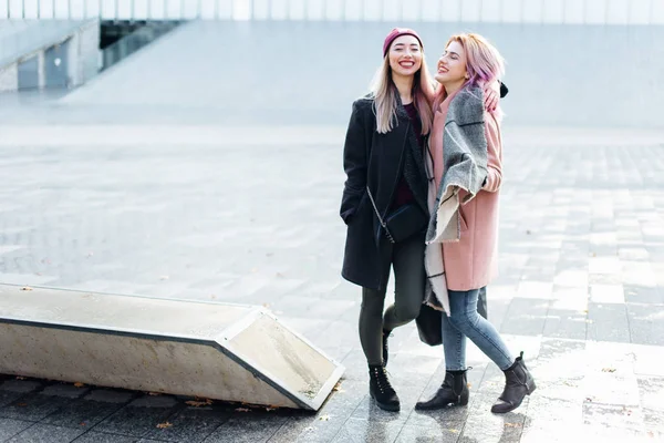 İki kız konuşurken birbirlerine ve gülüyor, sonbahar giyim için — Stok fotoğraf