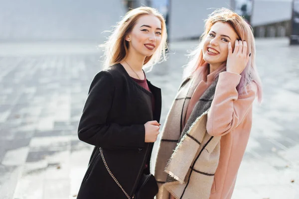 Две девушки разговаривают друг с другом и смеются, осенняя одежда — стоковое фото