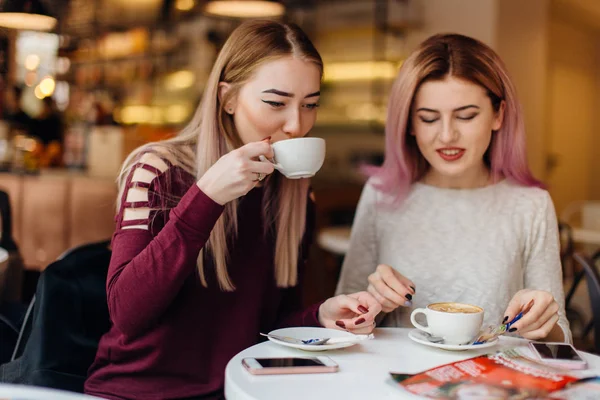Zwei Mädchen Fleisch am Kaffeetisch und reden miteinander, machen conv — Stockfoto