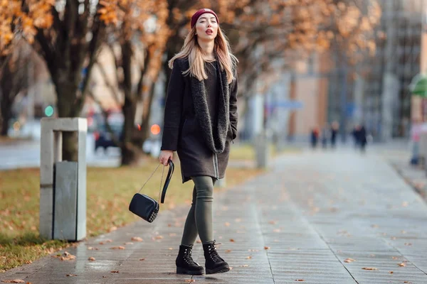 Bella ragazza di moda a piedi per strada con borsa e sorriso a — Foto Stock