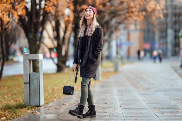 Όμορφο κορίτσι μόδας με τα πόδια στο δρόμο με την τσάντα και το χαμόγελο για να — Φωτογραφία Αρχείου
