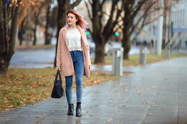 Красива дівчина моди гуляє на вулиці з сумкою і посміхається — стокове фото