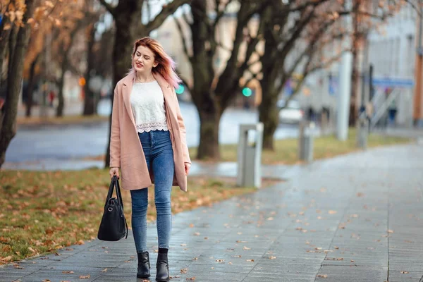Belle fille de la mode marcher dans la rue avec sac et sourire à — Photo