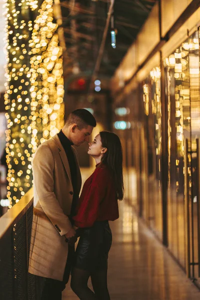 Casal lindo ficar no centro da loja e abraçar uns aos outros — Fotografia de Stock