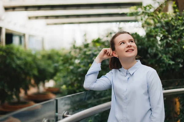 Place de bureau avec fille debout près des plantes. Souriant fille regarder c — Photo