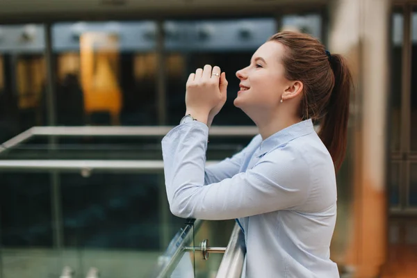 Office plaats met meisje stand in de buurt van planten. Lachende meisje kijken in de c — Stockfoto