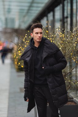 Moda erkek dimdik binaların yakınında sokakta. Kış, autu