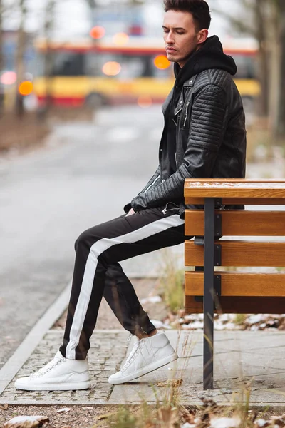 Traje moderno. Hombre de moda sentarse en el banco y mirar a su alrededor . —  Fotos de Stock