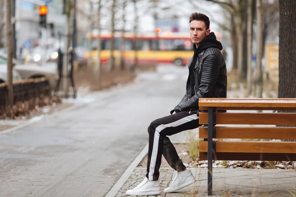 Une tenue moderne. Homme à la mode assis sur le banc et regardez autour de vous . — Photo