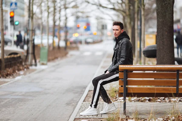 Une tenue moderne. Homme à la mode assis sur le banc et regardez autour de vous . — Photo