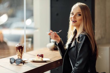 Güzel kız bir tabak lezzetli pasta ve waer gözlük tutun. Güneş