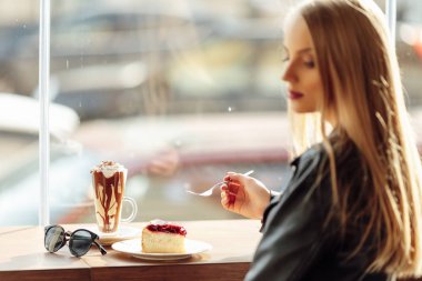 Güzel kız bir tabak lezzetli pasta ve waer gözlük tutun. Güneş