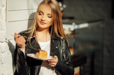Güzel kız bir tabak lezzetli pasta ve waer gözlük tutun. Güneş