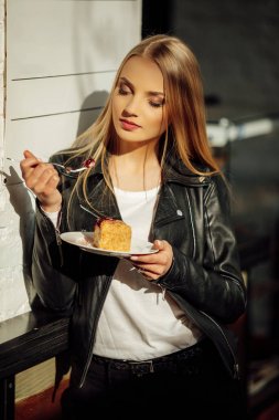 Güzel kız bir tabak lezzetli pasta ve waer gözlük tutun. Güneş