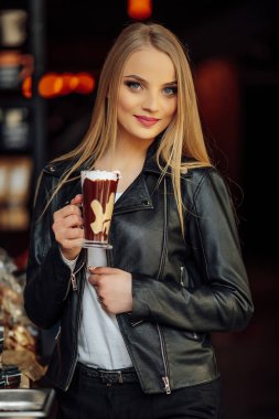 Güzel kız bir fincan lezzetli kahve ve waer gözlük tutun. Güneş