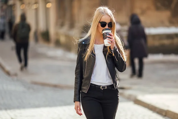 Jeune jolie fille marcher dans la rue avec une tasse de café sur son h — Photo