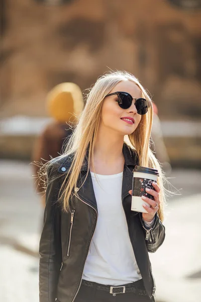 Giovane bella ragazza camminare per strada con una tazza di caffè sul suo h — Foto Stock