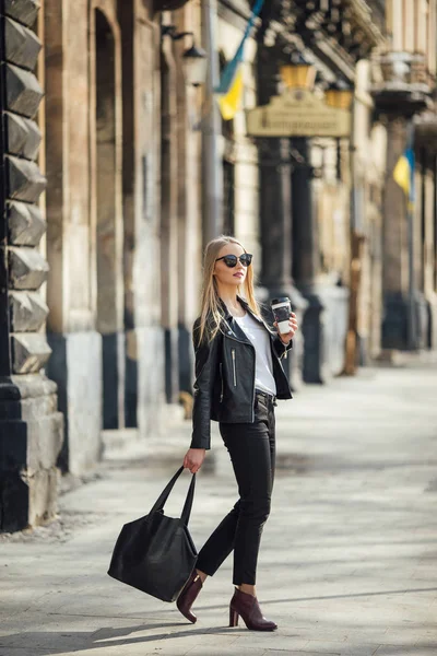 Jovem menina bonita andar na rua com xícara de café em seu h — Fotografia de Stock