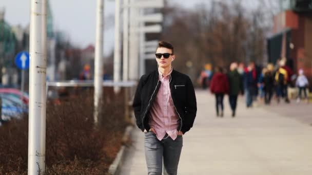 Νεαρός Άνδρας Περπάτημα Στο Δρόμο Ακούσετε Μουσική Και Φορούν Γυαλιά — Αρχείο Βίντεο